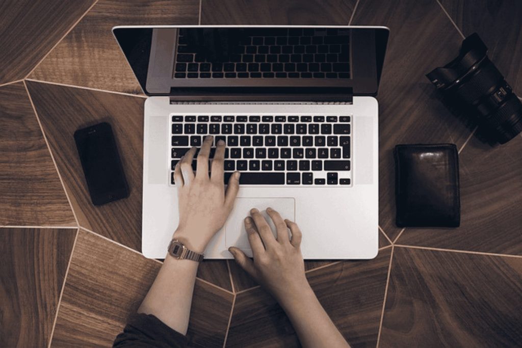 Hands typing on a keyboard of a laptop
